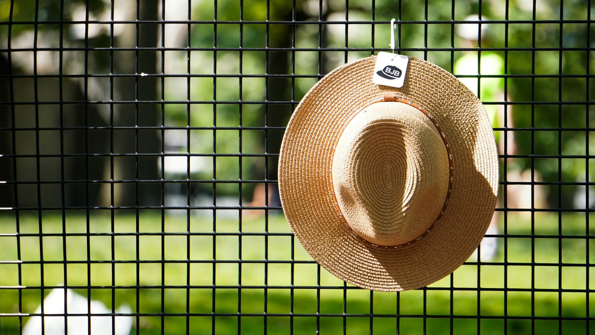 Straw hat hanging on fence